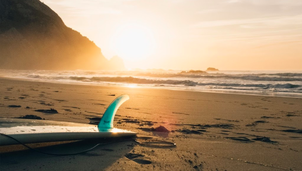 Surfboard on a beach at sunset